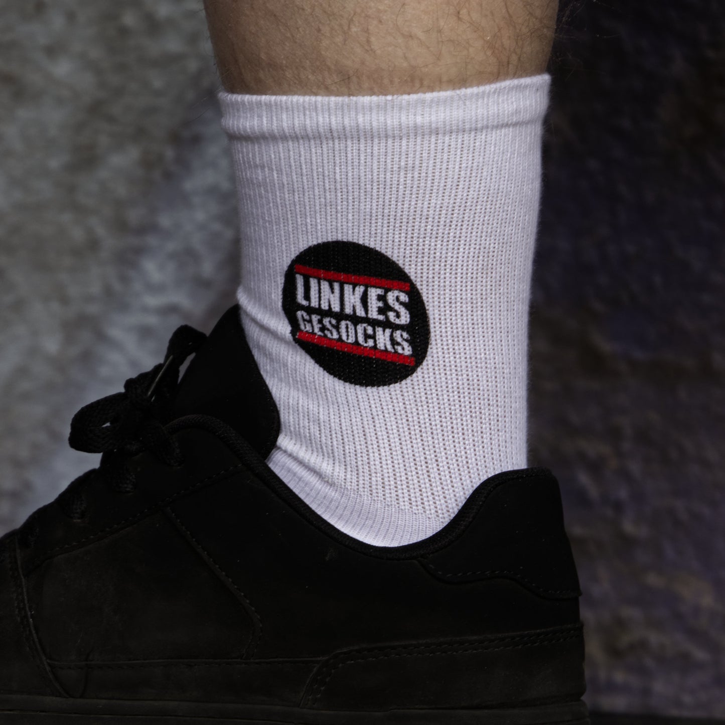 Fuß mit weißen Socken. Aufgedrucktes Motiv: Linkes Gesocks