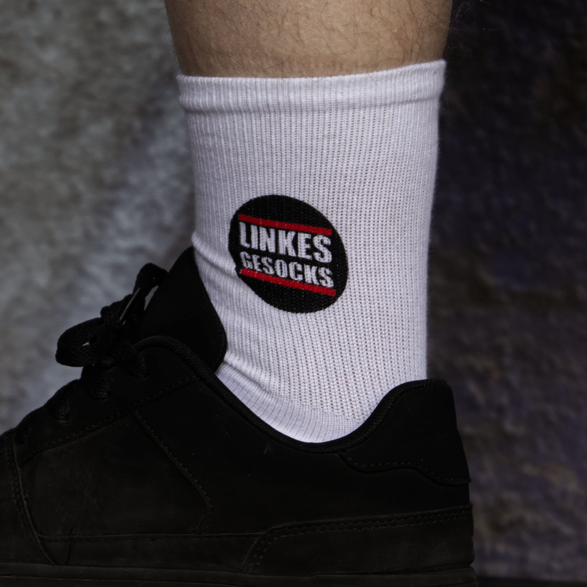 Fuß mit weißen Socken. Aufgedrucktes Motiv: Linkes Gesocks